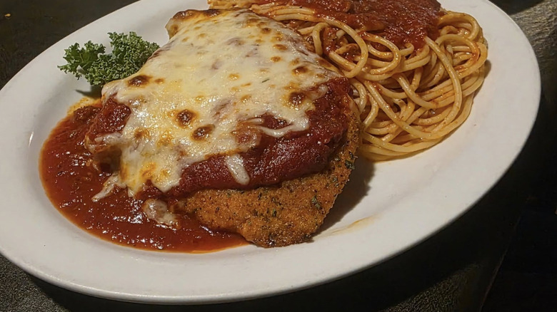 Angelo's chicken parm on a plate with spaghetti and sauce