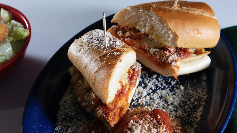 Grassi's chicken parm sandwich on a plate sprinkled with parmesan