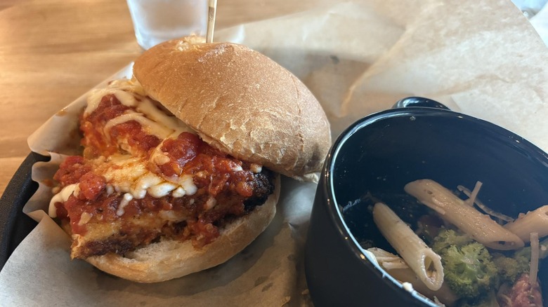 Ziti's chicken parm sandwich next to a pasta dish