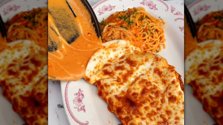 A cheese pour going on a chicken parm at Carbonara