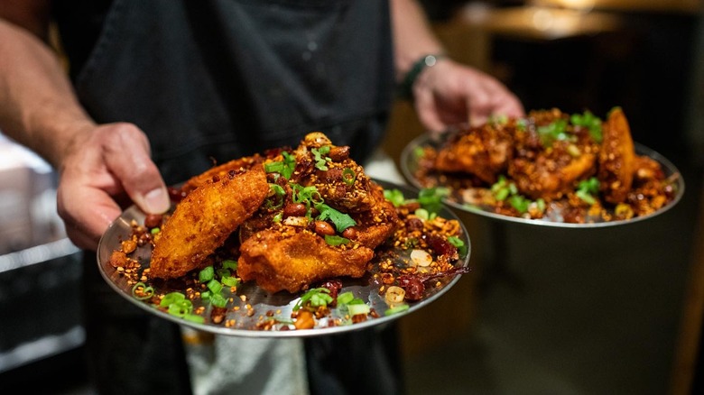 A chef holding crispy chicken wings at Shan in Bozeman