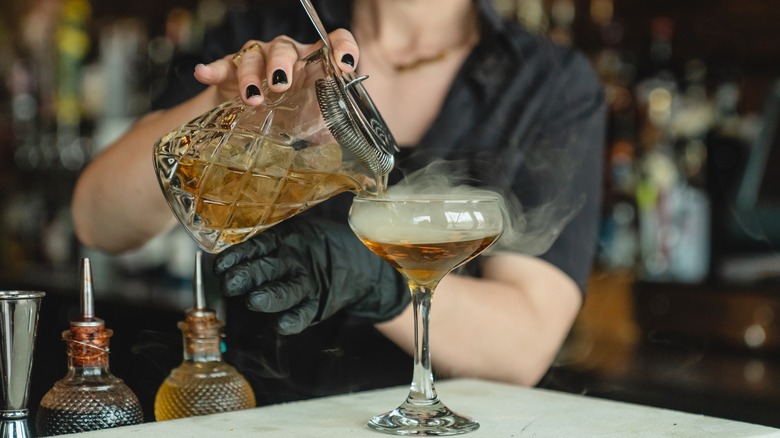 Woman pours a smoking cocktail