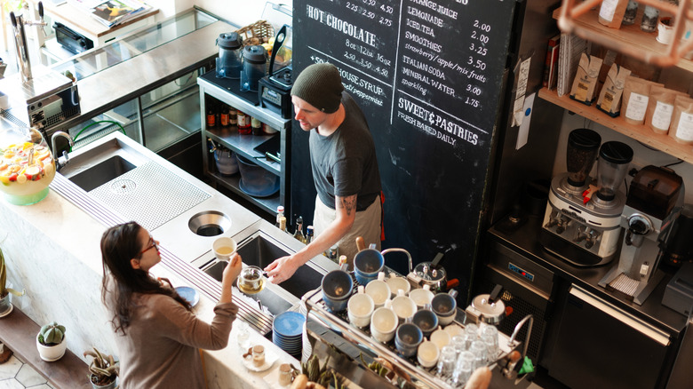 Barista serving a woman coffee at the counter