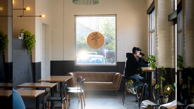 Seating area inside Native Coffee with young man sitting at table