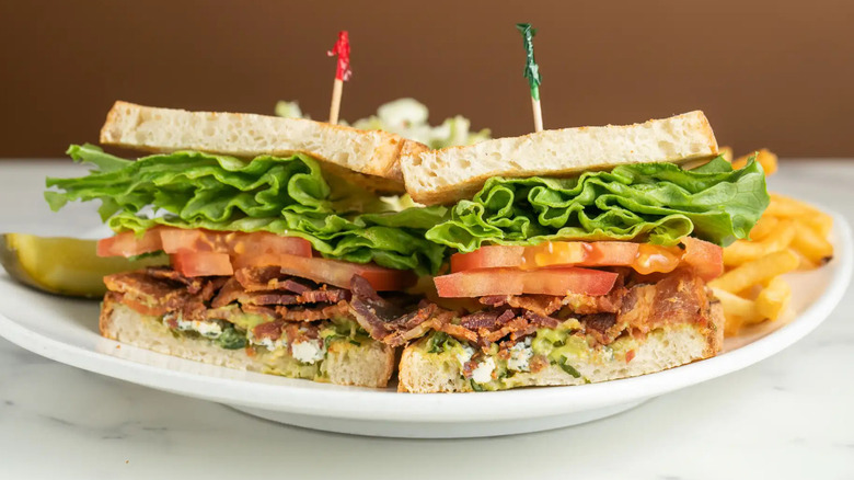 A sliced BLT sandwich with fries and a pickle from Mort's Deli