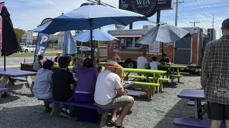 Guanacos Melting Pot with several picnic tables full of diners sitting in front of the truck