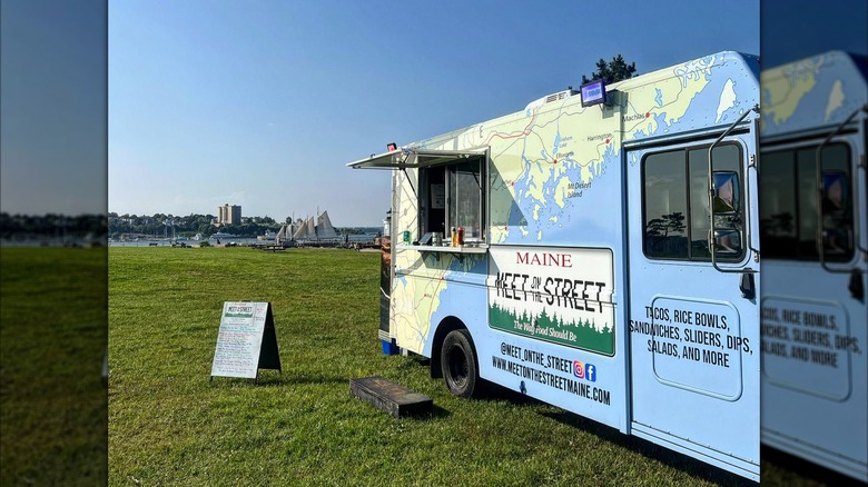 The blue exterior of Meet on the Street food truck with the bay in the background
