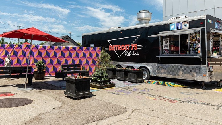 Exterior of Detroit 75 Kitchen food truck with benches outside