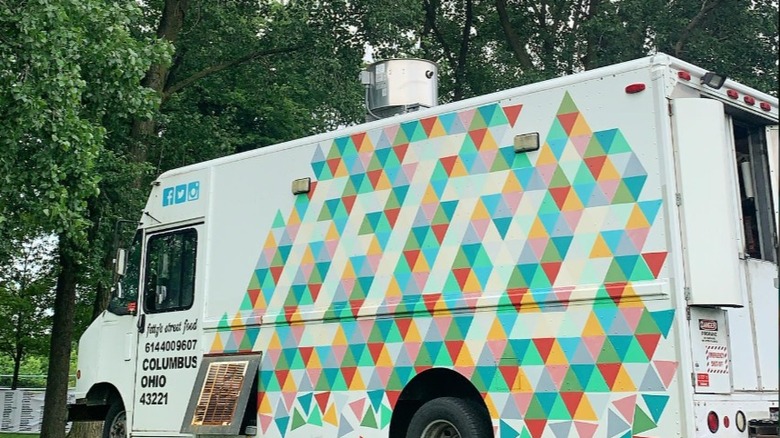 Exterior of Fetty's Street Food truck parked in front of trees