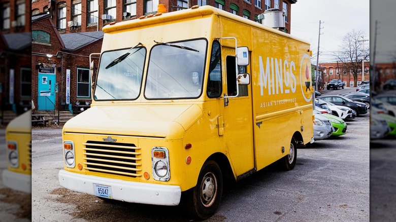 The yellow Ming's Asian Street Food truck parked in a busy lot