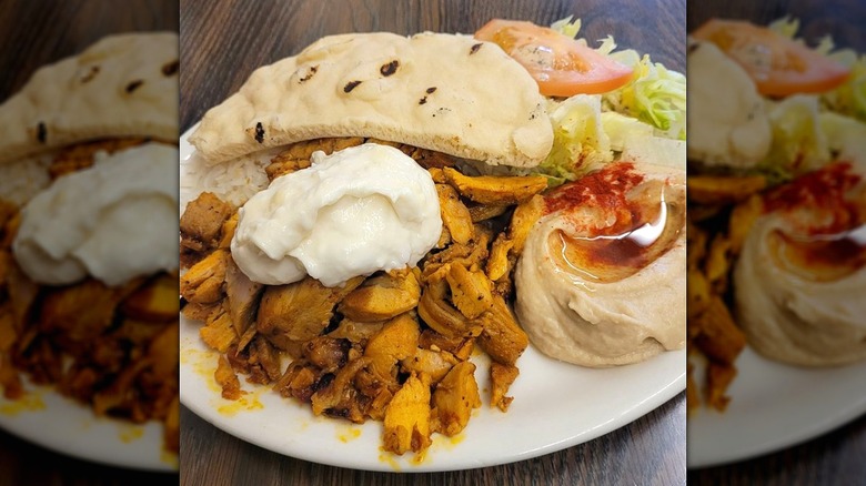 Chicken shawarma platter with pita, salad, and hummus at Haji-Baba