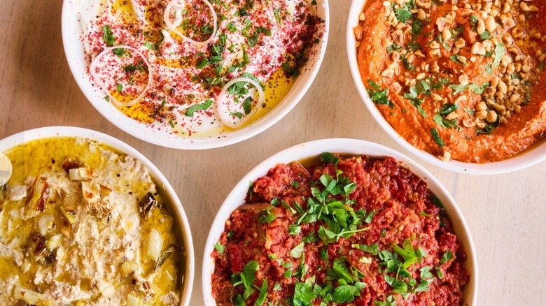 Assorted dips, including hummus, baba ghanoush, muhammara, and whipped feta at Safta Restaurant