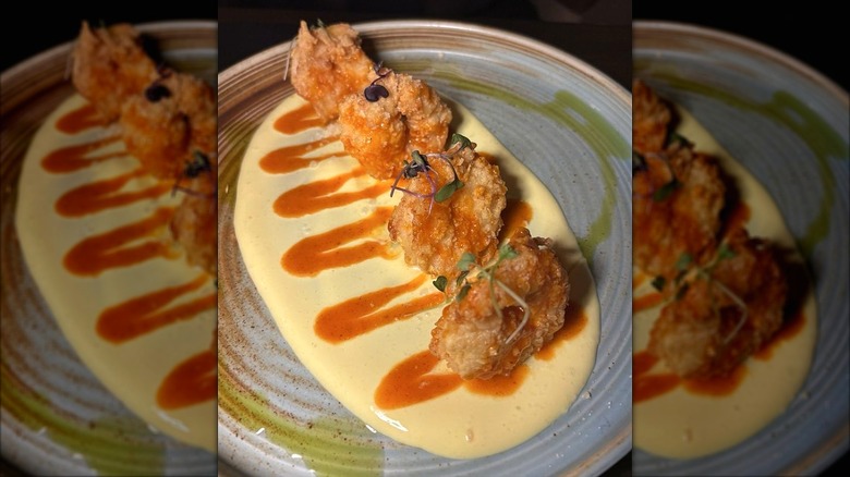 Spicy Moroccan shrimp with turmeric cream on a rustic grey ceramic plate at Pithari Mediterranean Cuisine