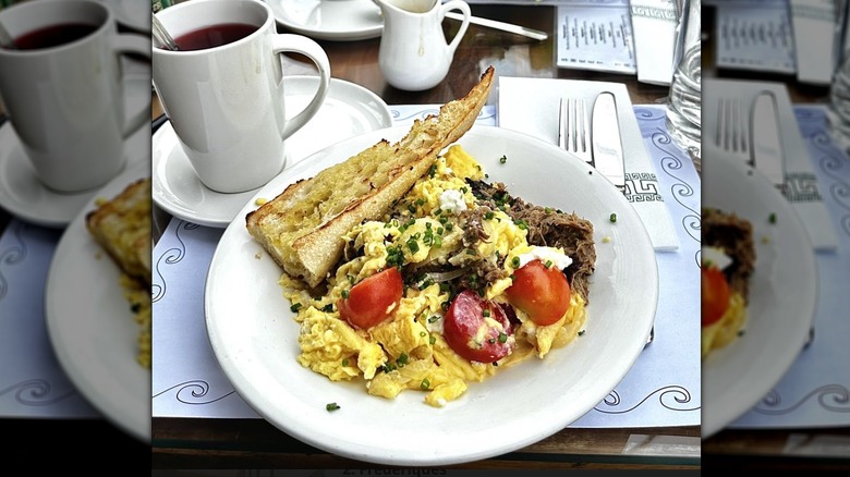 Strapatsada Greek egg dish with crusty bread on a white plate at Psomi