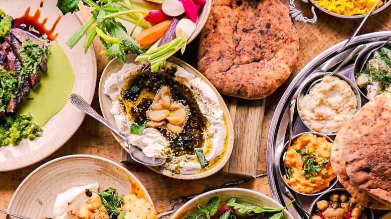 Assorted Mediterranean dishes, including hummus, crispy cauliflower, rice, and pita at MeeshMeesh Mediterranean