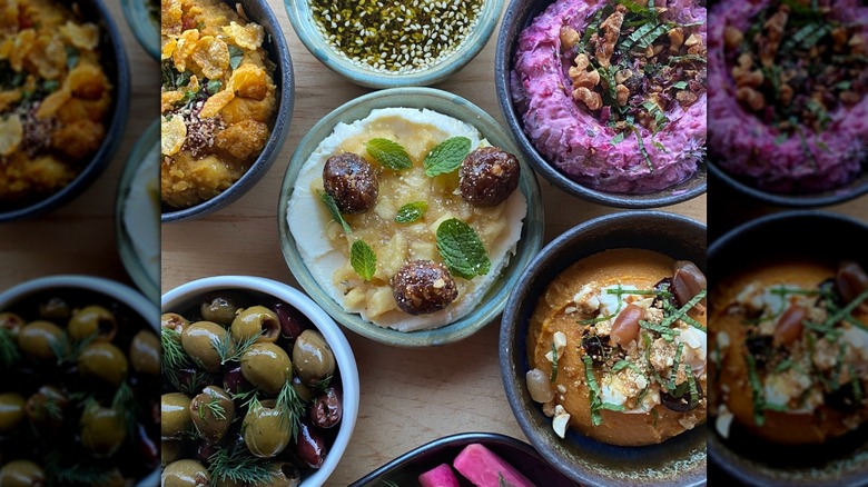 Close up of various dips and appetizers in small bowls at Ajja