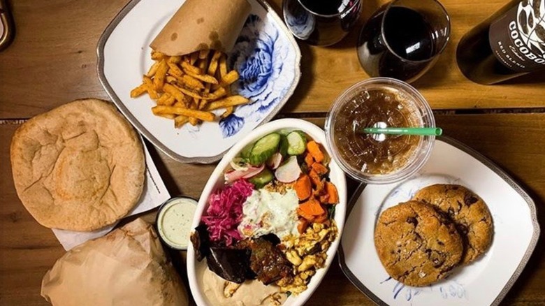 Food at Brassica, including fries, a drink, pita, a grain bowl, and cookies
