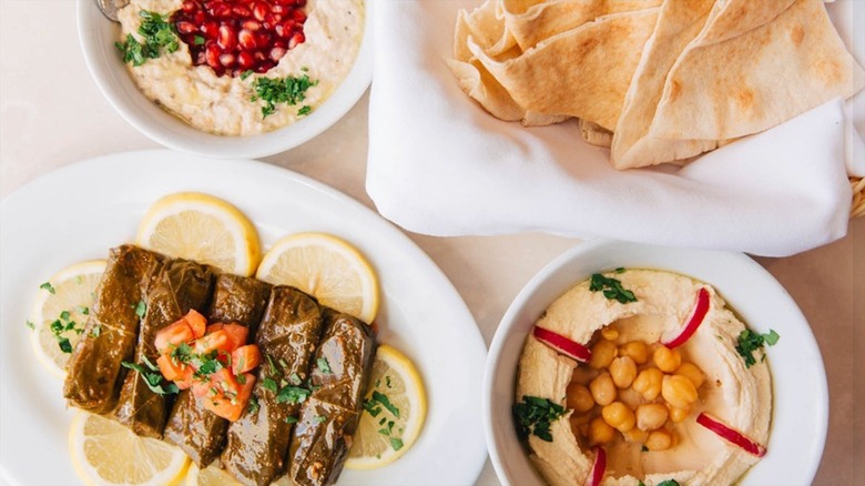 Assorted plates of appetizers at Leyla Fine Lebanese Cuisine including hummus, baba ghannoush, stuffed grape leaves, and pita