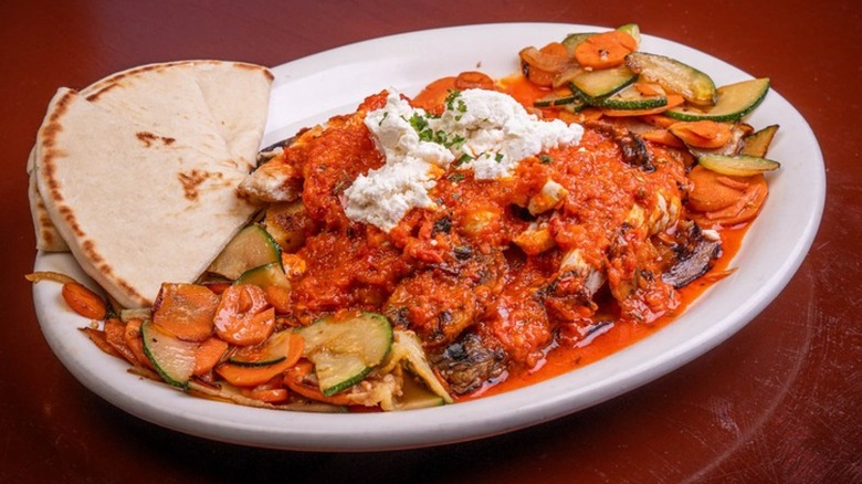 Vegetable medley with tomato sauce, fresh goat cheese, and pita over rice at The Med