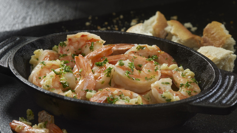 Garlic shrimp scampi in a cast-iron pan with crusty bread