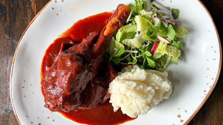A plate of lamb barbacoa with potatoes and salad at Kie Gol Lanee