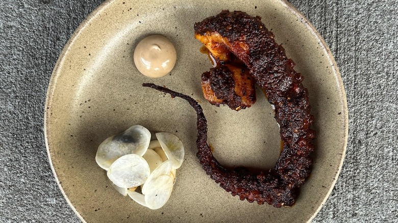 A plate of grilled octopus with coffee aioli at Acamaya
