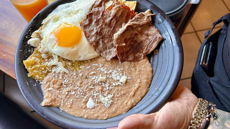 A plate of chilaquiles with egg, cecina, and beans at La Jalisciense