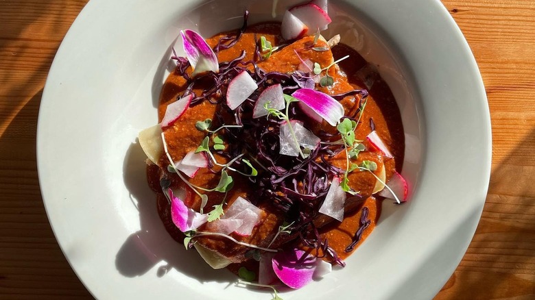 A bowl of beet mole and braised pork enchiladas at Chilangos
