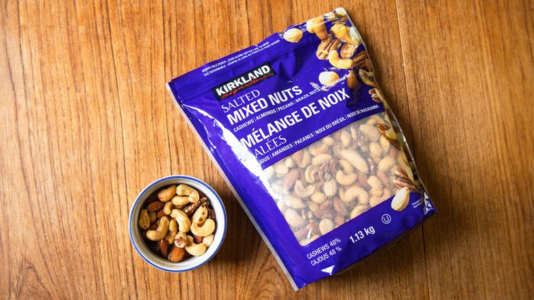 A package of Costco's Kirkland Signature salted mix nuts next to a small bowl of same nuts