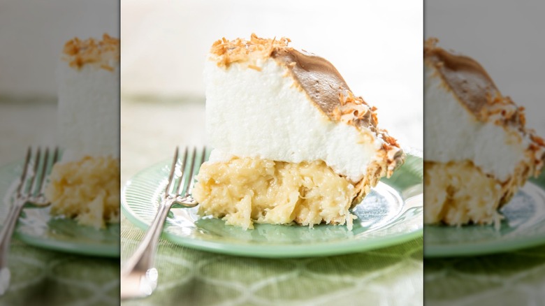 Slice of coconut meringue pie on a green plate
