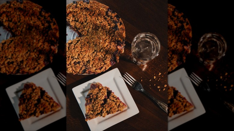 Whole and slice of North Shore Berry Crumb Pie on square white plate
