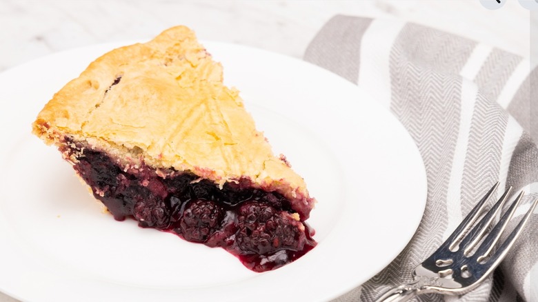 Slice of Marionberry Pie on round white plate