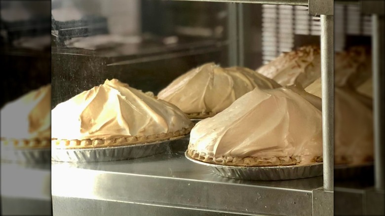 Lemon meringue pies on display in a case