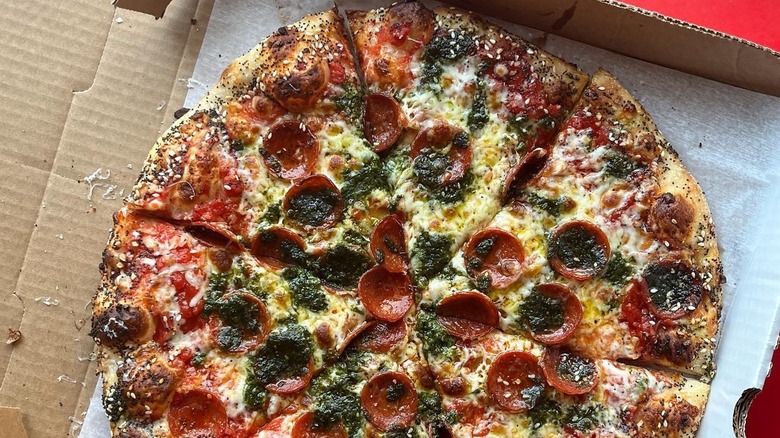 A pizza in a takeout box from Americana Pizza