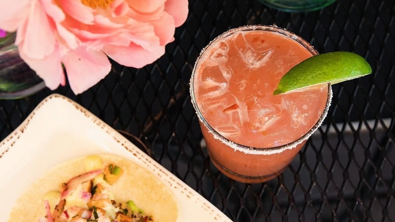A plate of tacos next to a margarita from Hatch Taquería & Tequilas
