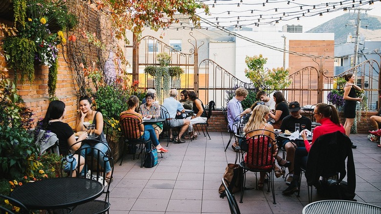Patio at Plonk Wine with views of city buildings and mountains