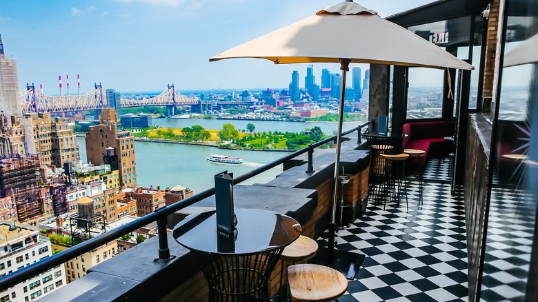Outdoor space of Ophelia Lounge with the East River in the background