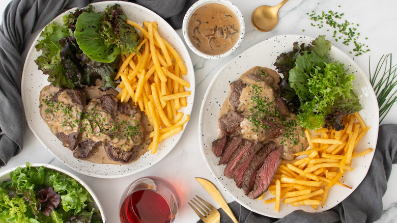 Overhead shot of steak Diane with frites and salad.