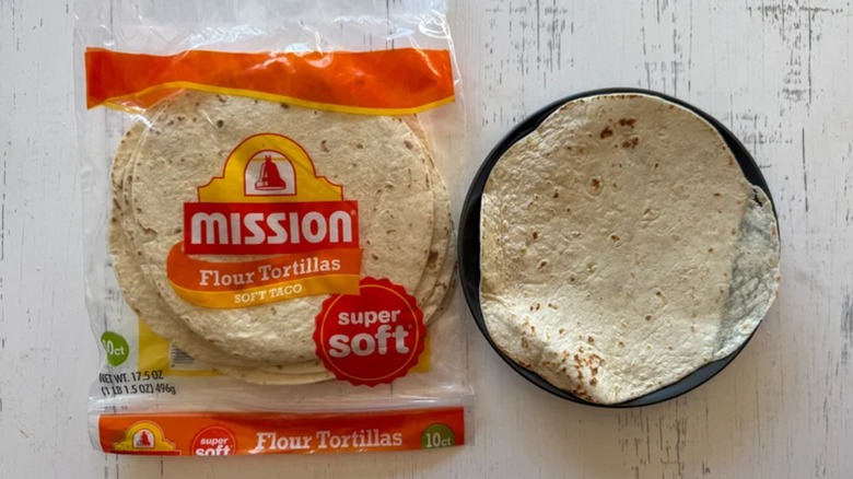 Bag of Mission flour tortillas next to a tortilla in a plate