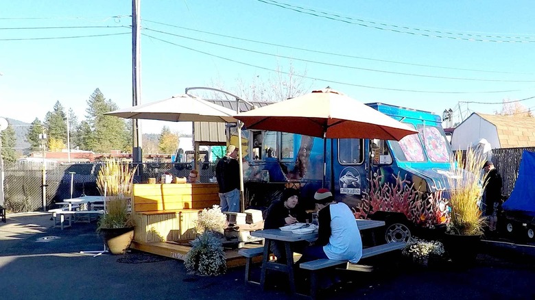 Food truck and outdoor eating area at Raw Dead Fish