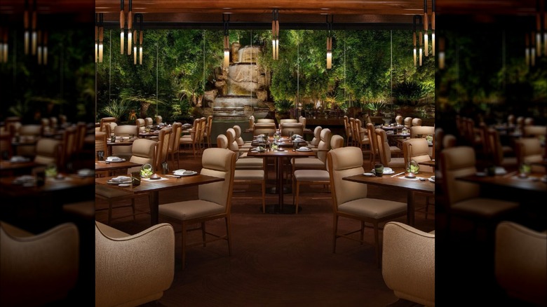 Dining area inside Mizumi, with plants and a waterfall in the background