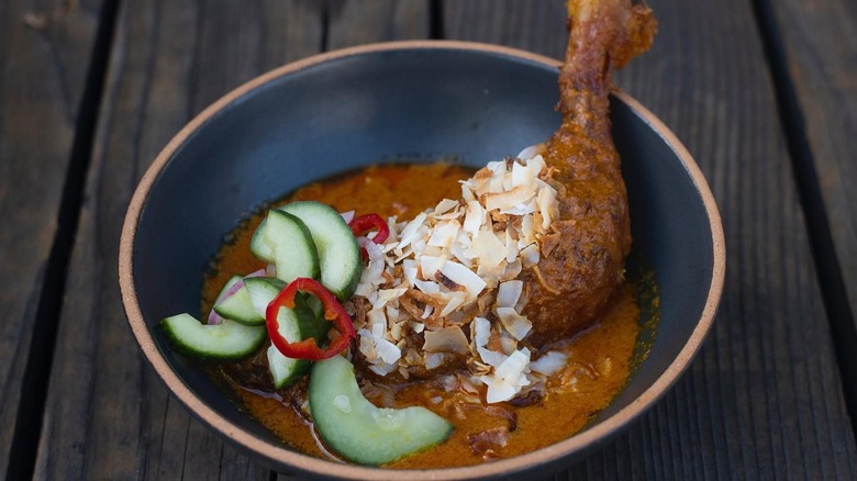 A plate of chicken with curry sauce at Kin Khao