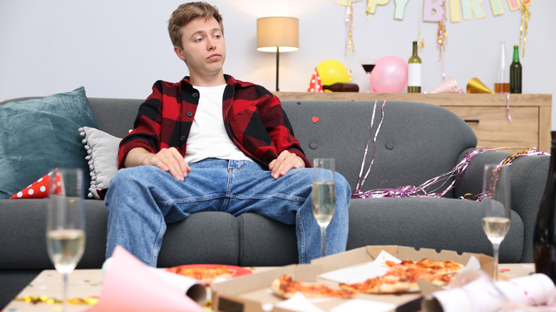 A man surrounding by several empty pizza boxes.