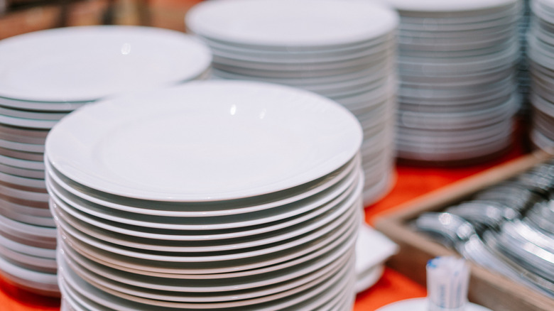 Stacks of white plates at a buffet
