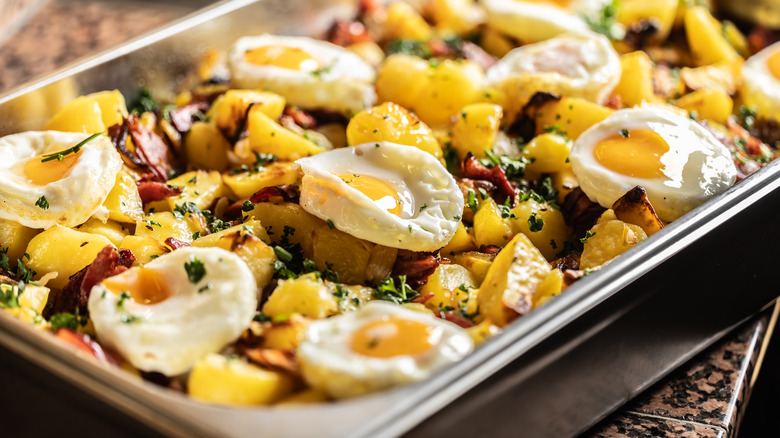 Eggs and potatoes with parsley in a metal buffet tray
