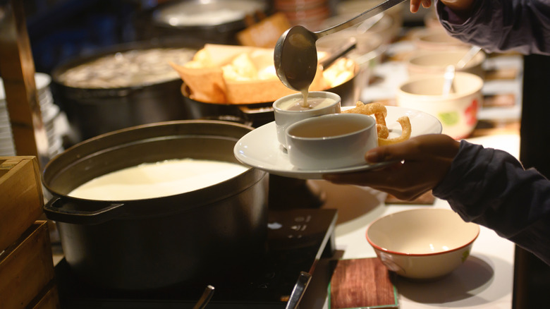Someone filling a bowl with soup at the buffet
