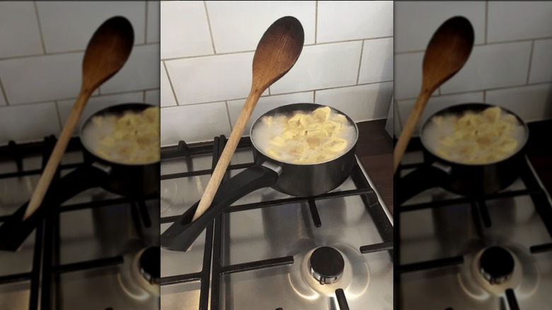 Wooden spoon propped up in pot handle hole.