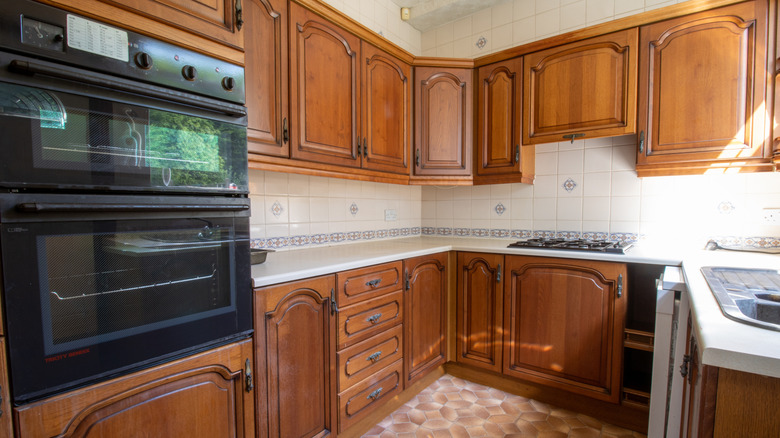Kitchen with wood-paneled cabinets and tile backsplash.