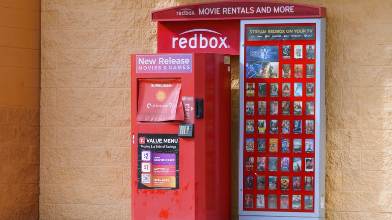 Redbox rental kiosk against a brick wall