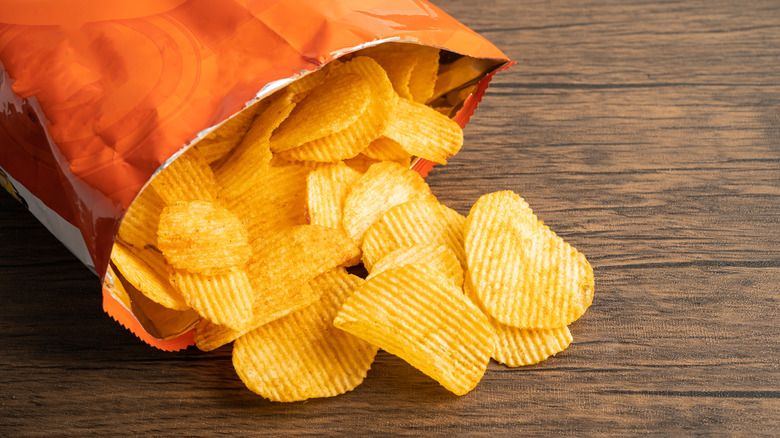 open bag of potato chips on a wooden table